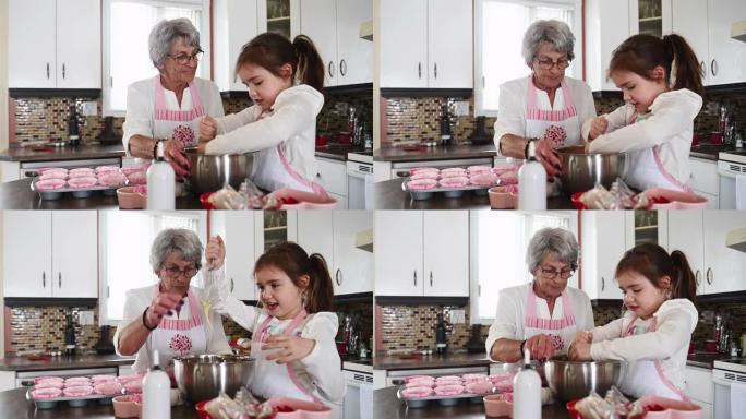 小女孩和祖母一起烹饪情人节松饼
