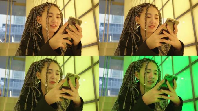 一个女人用智能手机编织头发