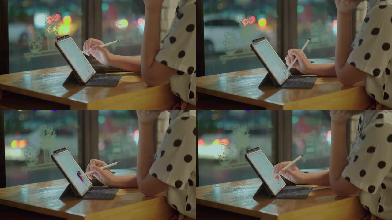 亚洲自由职业者女性晚上在咖啡馆使用笔记本电脑