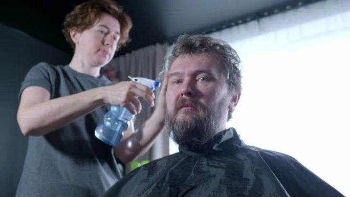 一个女人正在给一个男人理发