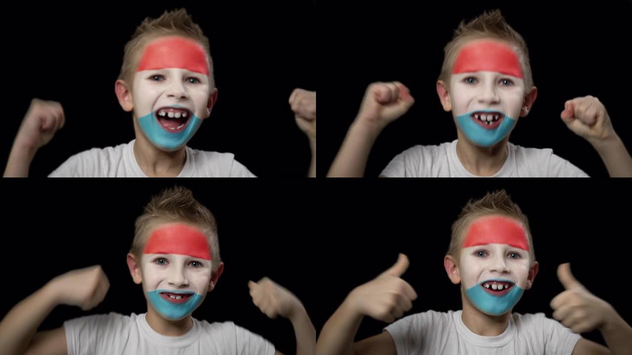 快乐男孩为他最喜欢的卢森堡队的胜利而欢呼。脸上涂着民族色彩的孩子。