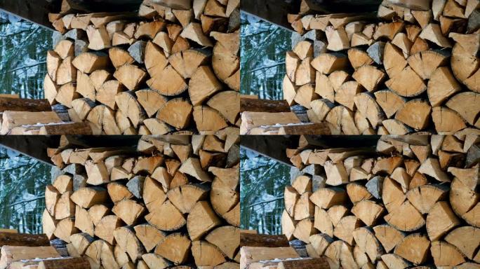 堆放在院子里一个大原木木桩上的切碎和锯切的树干的特写镜头。为壁炉和炉子准备的柴火。4K