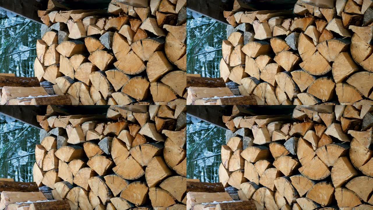 堆放在院子里一个大原木木桩上的切碎和锯切的树干的特写镜头。为壁炉和炉子准备的柴火。4K