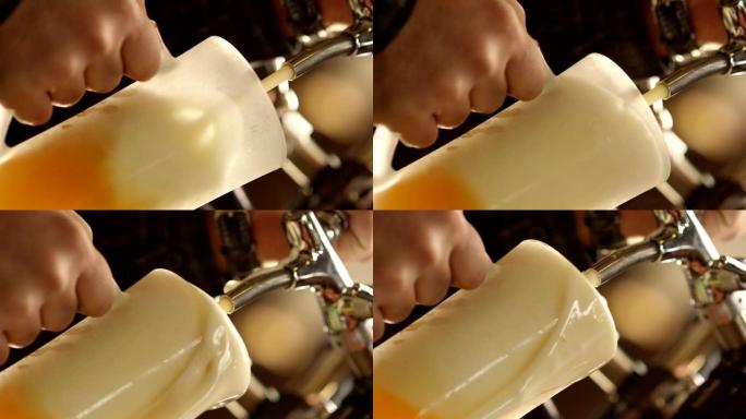将冷啤酒倒入玻璃杯中。酒保在酒吧里倒精酿啤酒。啤酒酿造大师的手从小桶中倒入淡淡的生啤酒泡沫。烈性啤酒