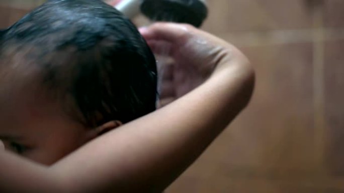 一名亚洲女婴正在被她的母亲洗头。