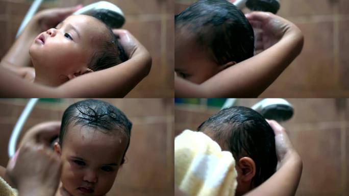 一名亚洲女婴正在被她的母亲洗头。