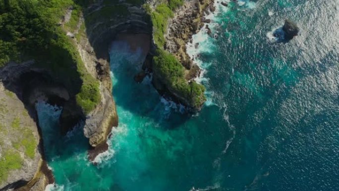 巴厘岛，蓝色的海洋和岩石丘陵，覆盖着热带树木。