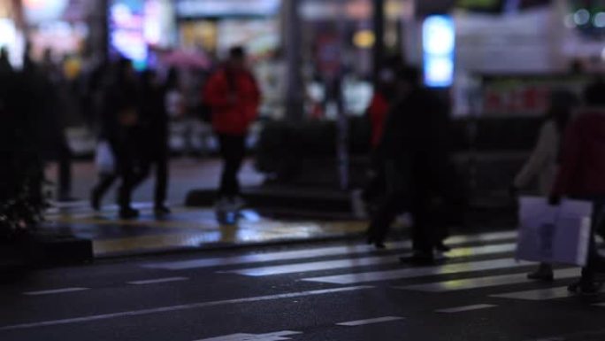 晚上在新宿东京下雨天在十字路口散步的人