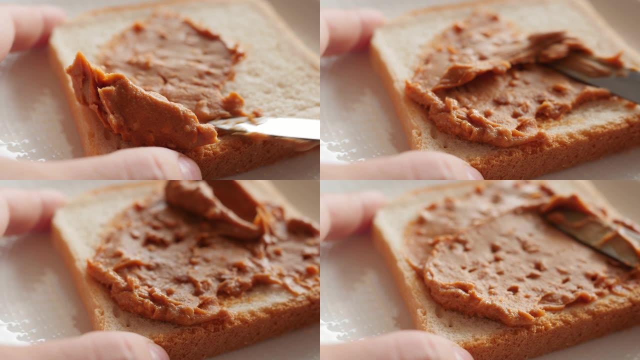 在烤面包上撒花生酱，制作三明治