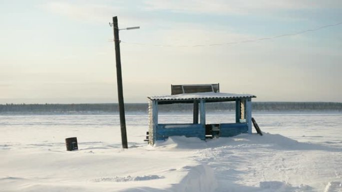 西伯利亚冰冻的叶尼塞河岸边空荡荡的码头，背景是风景秀丽的松冬林。俄罗斯。4K