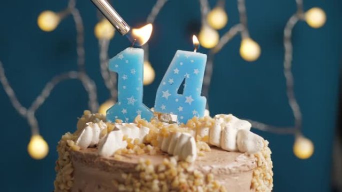 蓝色背景上有14个数字蜡烛的生日蛋糕。蜡烛着火了。慢动作和特写视图