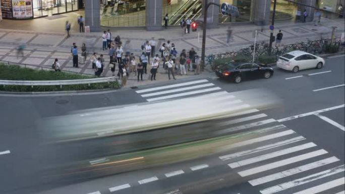 日本大阪车站高峰时段，在人行横道上行走的匿名人群。延时镜头