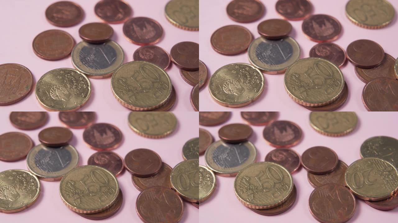 粉红色背景上的欧元硬币和美分