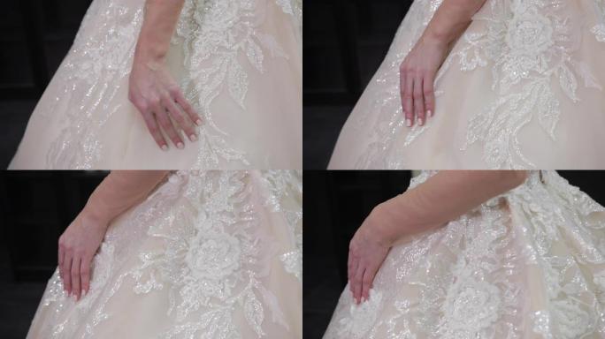 新娘穿着的白色婚纱的特写镜头，触摸薄纱使波浪