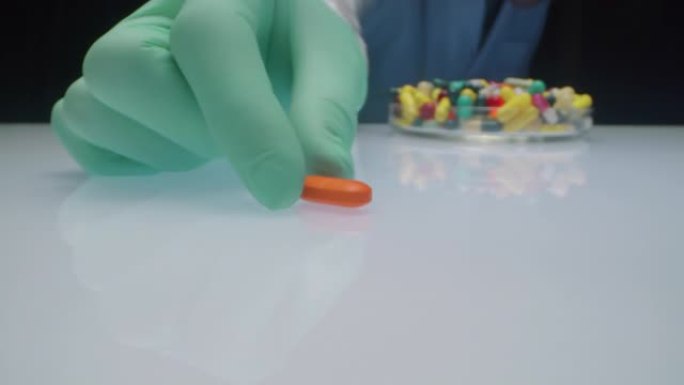 实验室工作人员将橙色药丸移到相机上