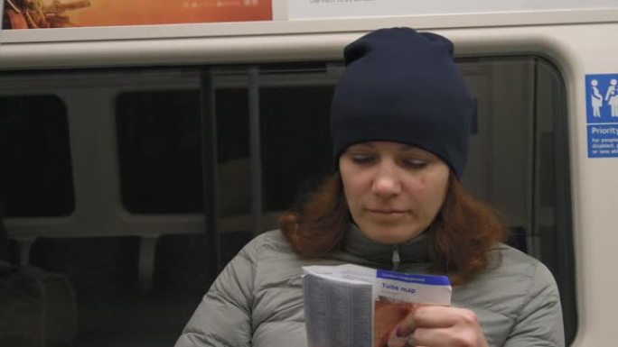 乘坐地铁旅行并在纸质地图中寻找的女孩