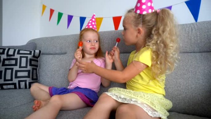 小女孩们最好的朋友玩糖果和坐在一起看电视