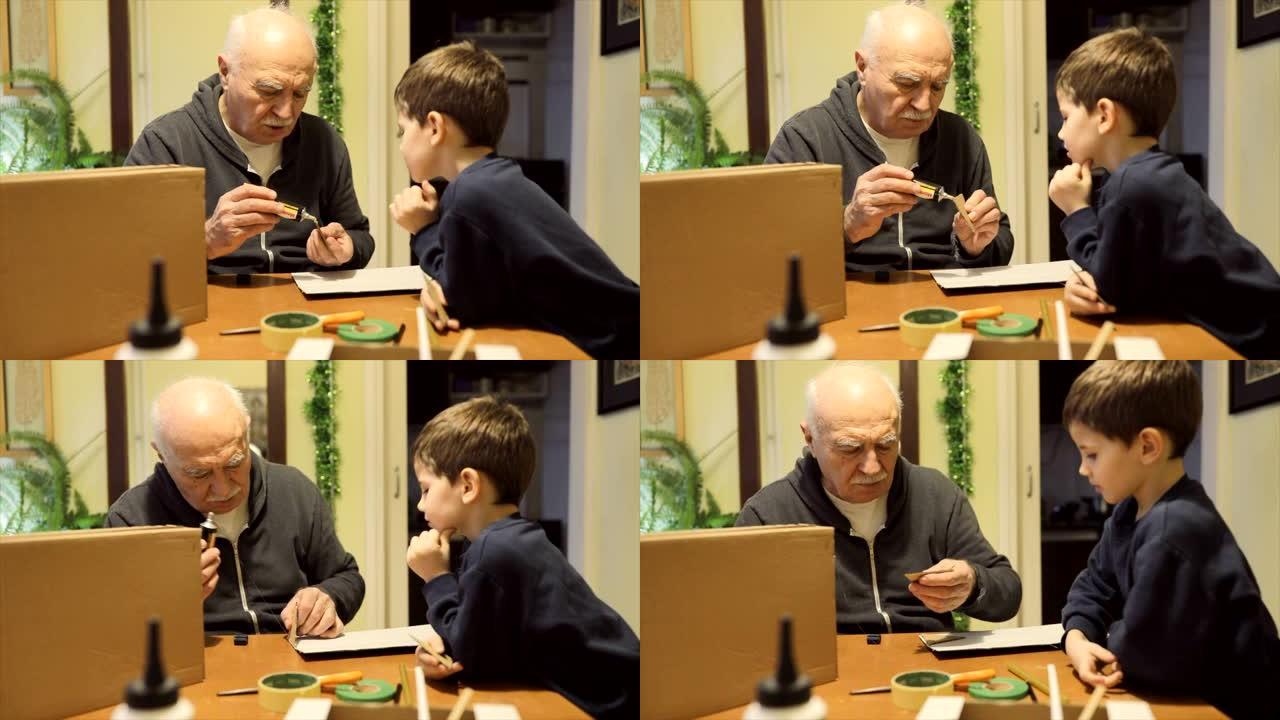 小男孩和他的祖父一起做纸箱
