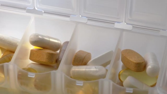 药盒中的每日部分药物。药物和膳食补充剂概念，宏观镜头