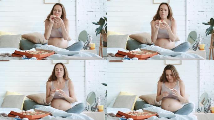 特写孕妇在家吃东西。怀孕吃披萨的肖像