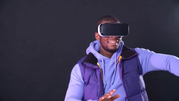 虚拟现实游戏。快乐的非裔美国人使用头戴式显示器