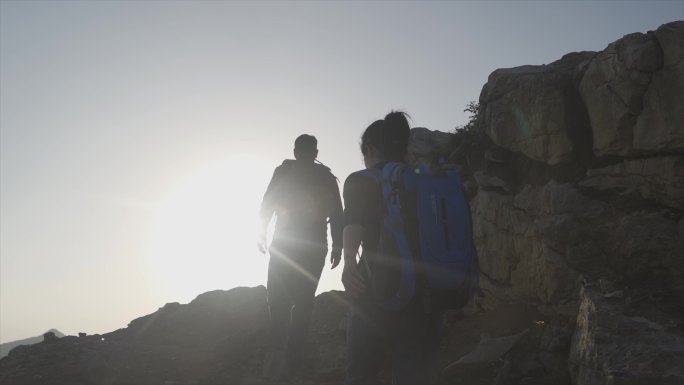 团队登山背影攀登顶峰徒步旅行团队合作精神