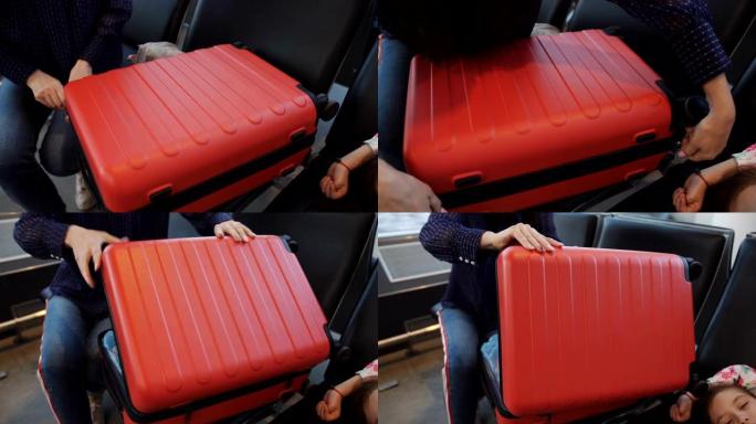 机场的那个女人打开红色的手提箱，拿一个钱包。