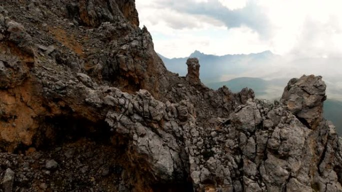 日落时无人机飞过尖锐的岩石露头的特写鸟瞰图。用于极端登山的陡峭的岩层山。飞行穿越旅行视频