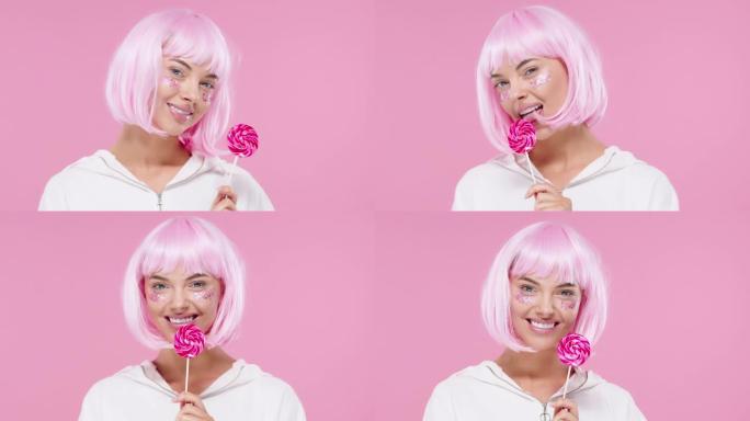 美丽的模特女人，时尚的粉红色发型和美丽的闪光化妆，拿着彩色的甜棒棒糖糖果