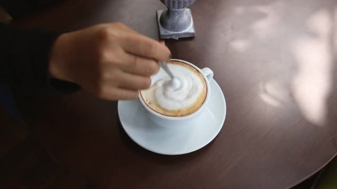 女人用手倒糖，用勺子搅拌咖啡，咖啡时间。