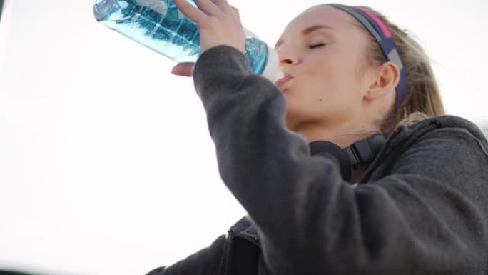 俯视女人喝一口水补充水分有氧蓝牙