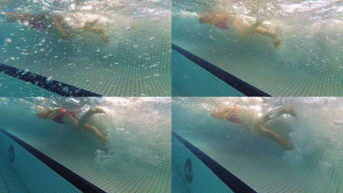 水下少女在游泳池慢动作游泳