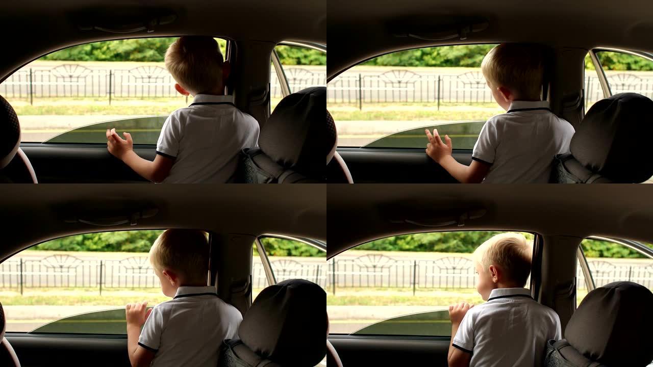 小男孩坐在汽车的后座上，他看着车窗外。
