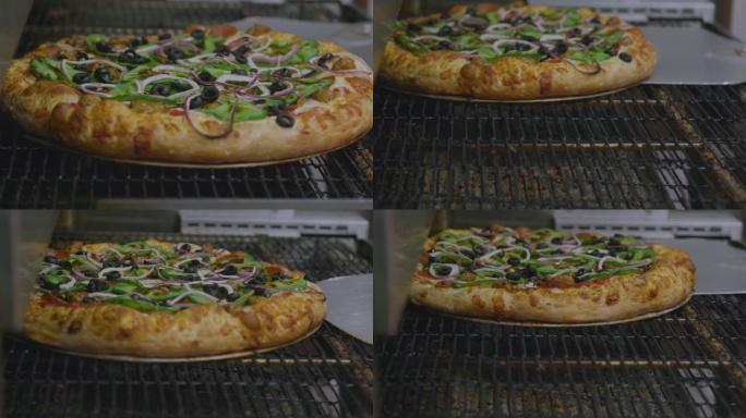 蔬菜披萨在传送带披萨烤箱上烘烤，餐厅厨房配有披萨皮