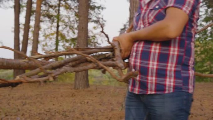 在森林中携带干原木的男子的短枪