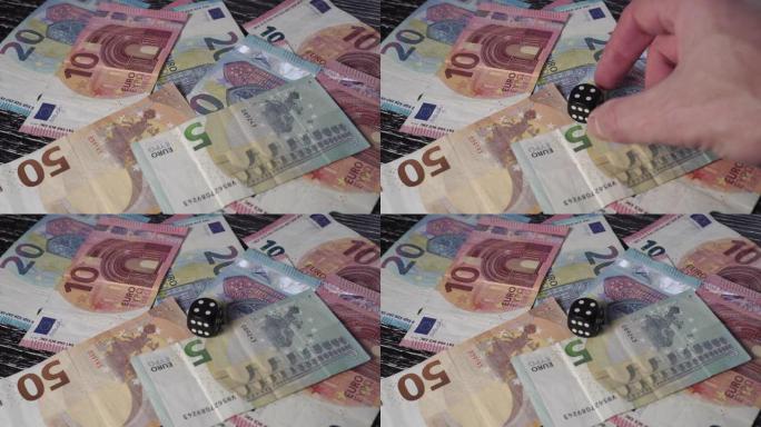 在一堆欧元纸币上，一只手在上面放了一个数字4的黑色骰子