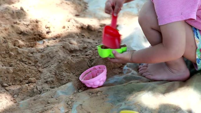 一个孩子在后院玩沙子的特写镜头