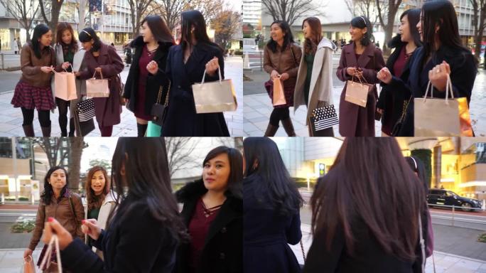 一群亚洲妇女在圣诞节走在购物街上