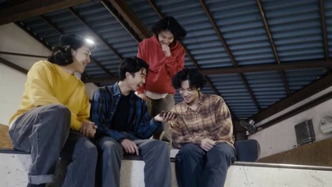 一群日本男孩在智能手机上观看滑板视频