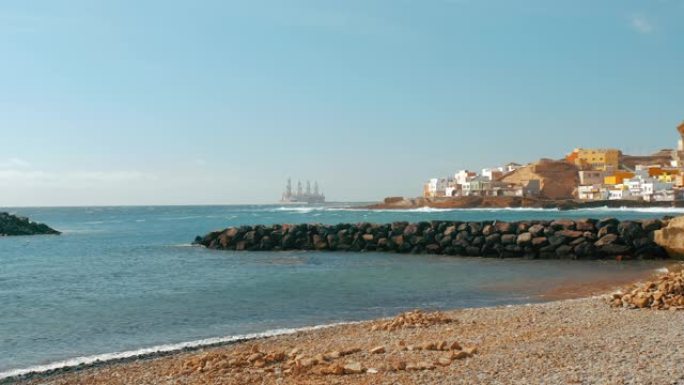 海湾毗邻海边。渔船和邮轮游艇。背景下的欧洲小镇和石油钻井平台