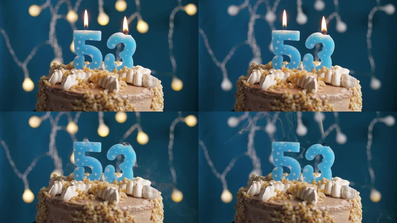 蓝色背景上有53号蜡烛的生日蛋糕。蜡烛吹灭了。慢动作和特写视图