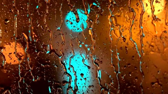 忧郁的雨水-城市在夜间通过下雨的窗户