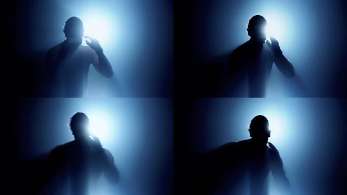 做影泰拳的人的剪影背后有光，面对镜头有雾和漏光效果。高加索男性。中枪。