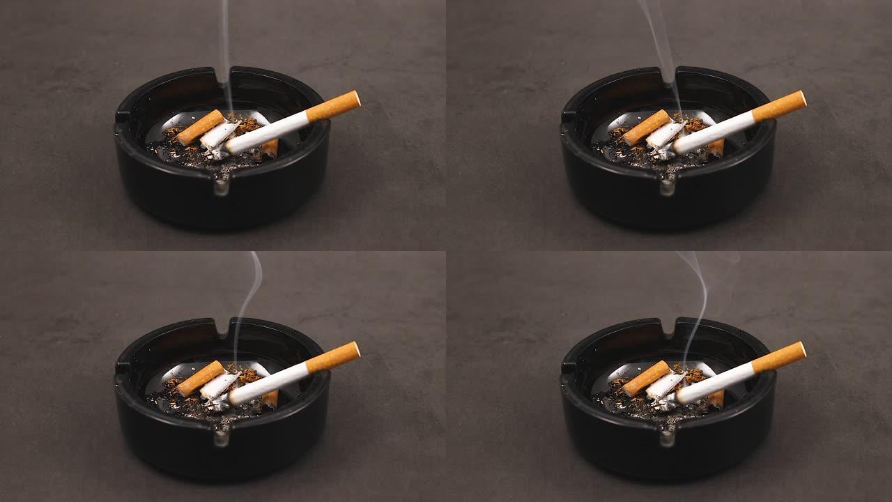 在黑色烟灰缸中燃烧的香烟和烟雾流动