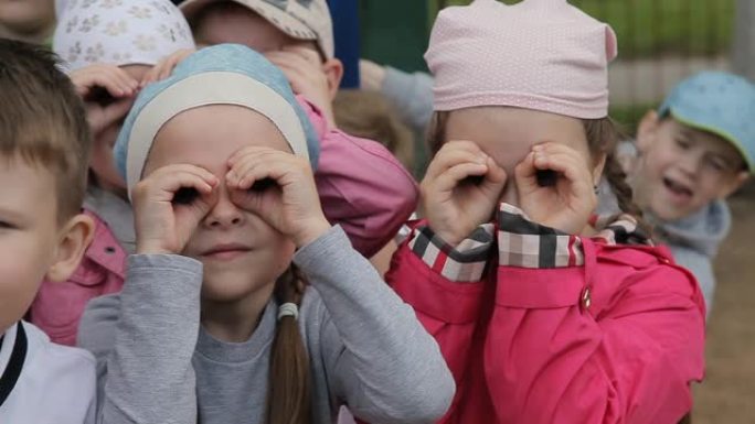 小孩女孩和男孩通过想象的双筒望远镜看，