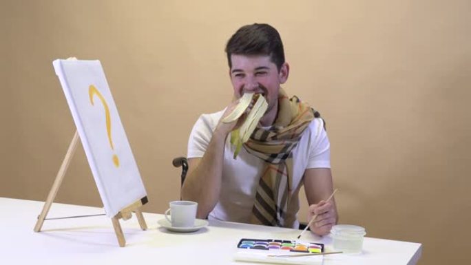 艺术家坐在桌子旁吃着香蕉，等待灵感的到来