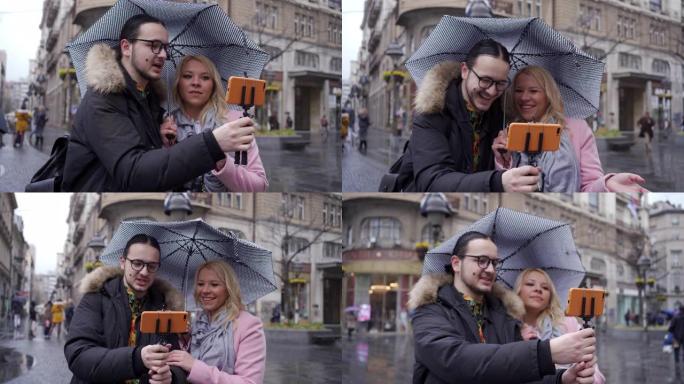 旅行视频记录器在下雨时在自拍杆上记录手机上的vlog