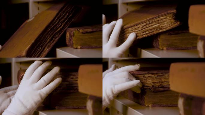 双手戴着白手套，非常小心地把一本旧古董书放在架子上。库存镜头。藏有黄页的古书