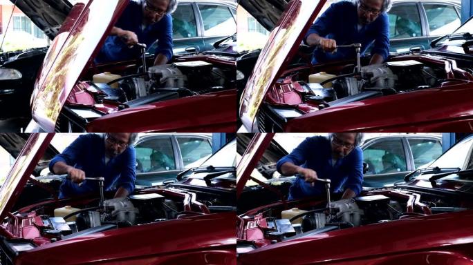 平移镜头，汽车修理工在机械车库拧紧发动机上的螺栓。维修服务和检查车。汽车定期维护检查