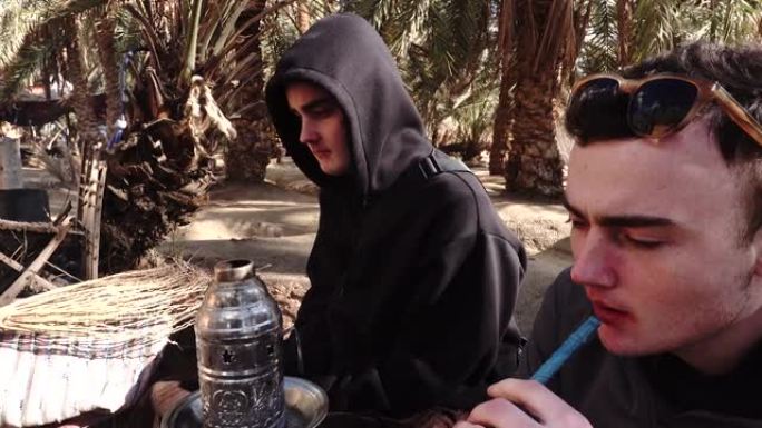吸烟水管两个外国男人抽水烟喝奶茶